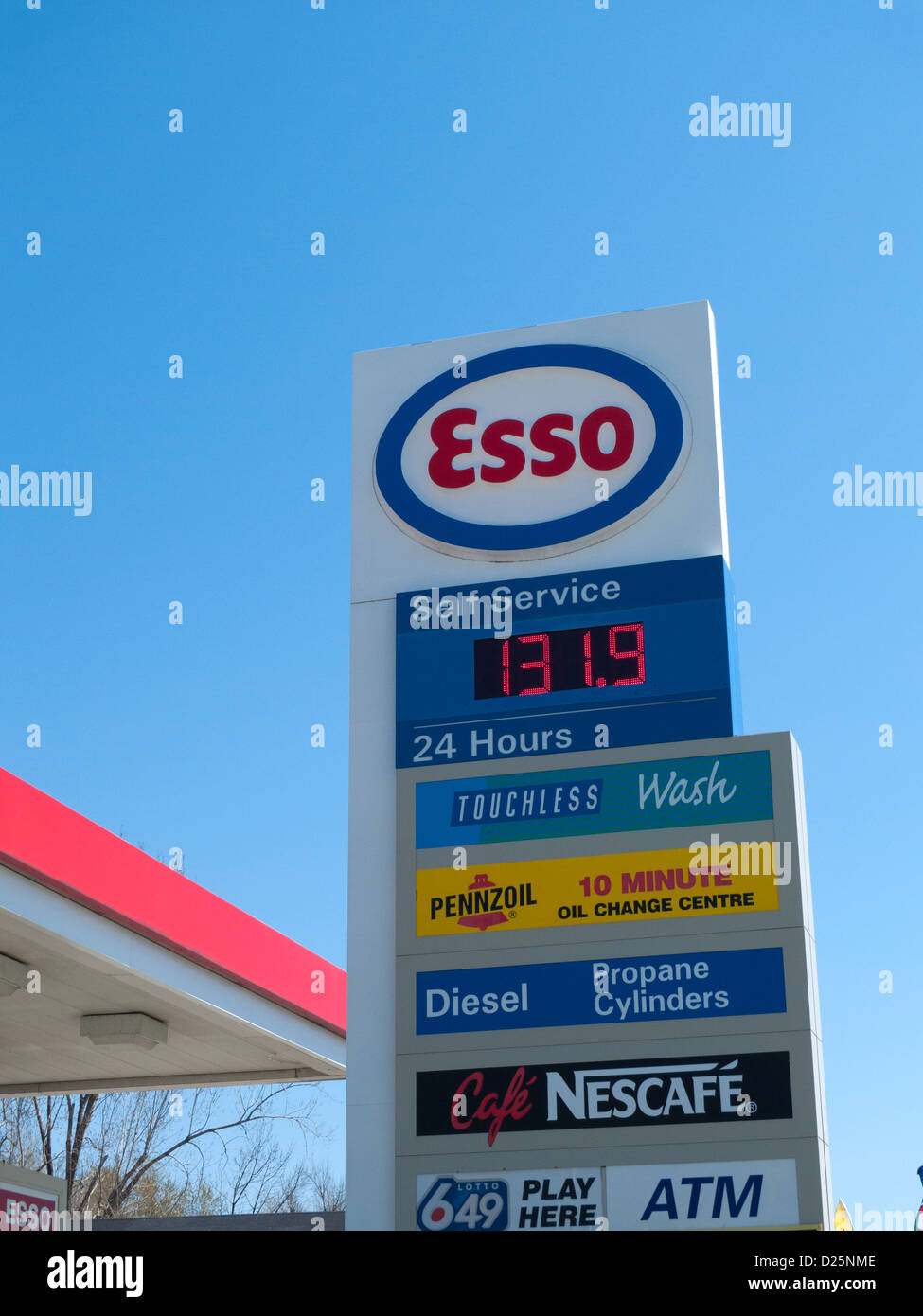Esso gas station sign outside a petrol station showing gas prices open 24 hours in advertisements blue sky copy space in 2012 Canada  KATHY DEWITT Stock Photo