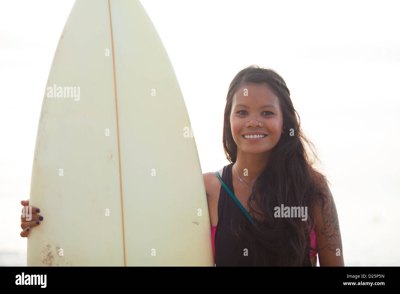 Young beautiful asian woman with long black hair holding surf board Stock Photo