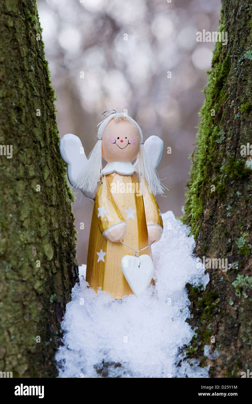 A decorative wooden angel in a snowy wood. Stock Photo