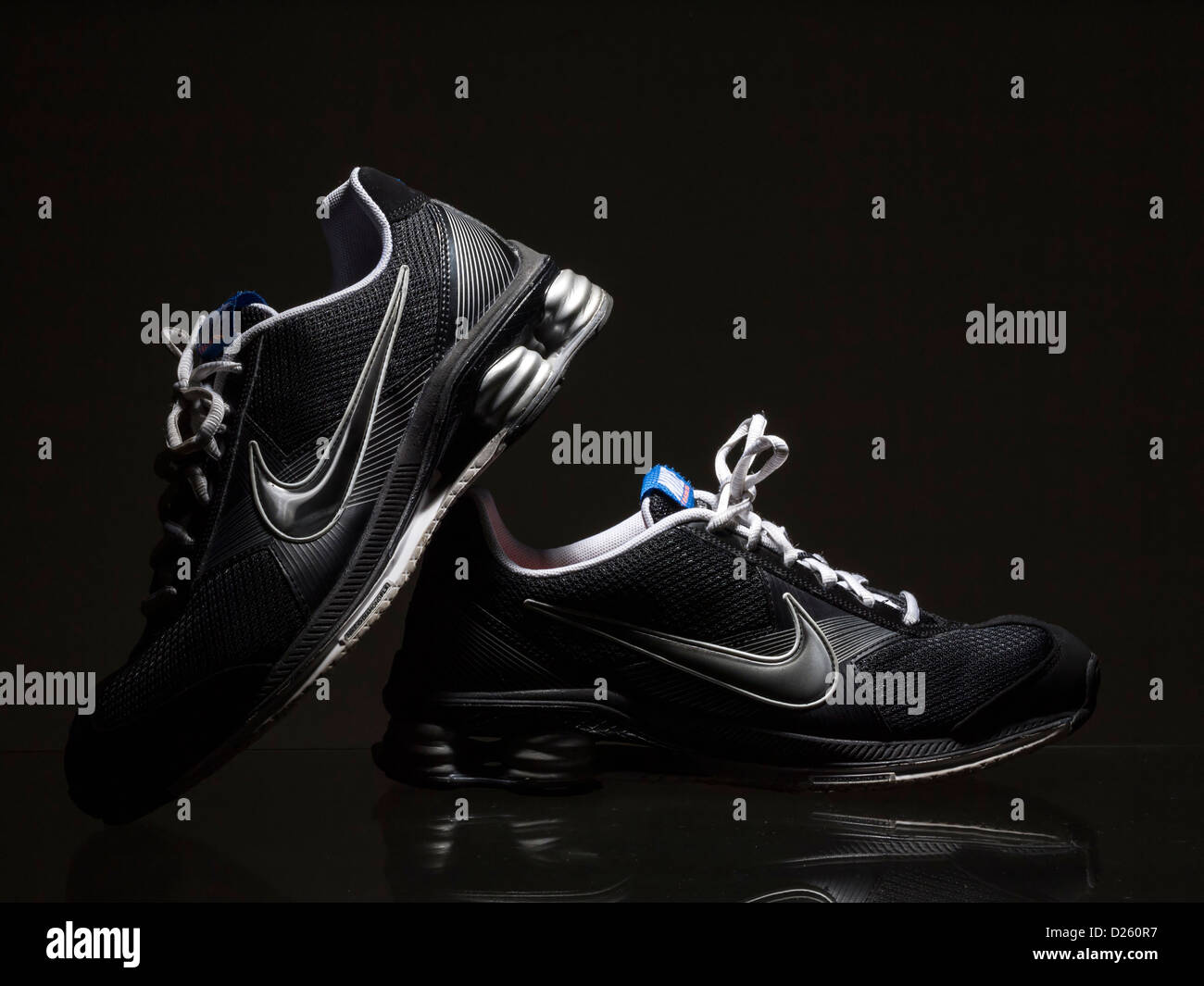 Pair of black Nike running shoes on dark background Stock Photo - Alamy