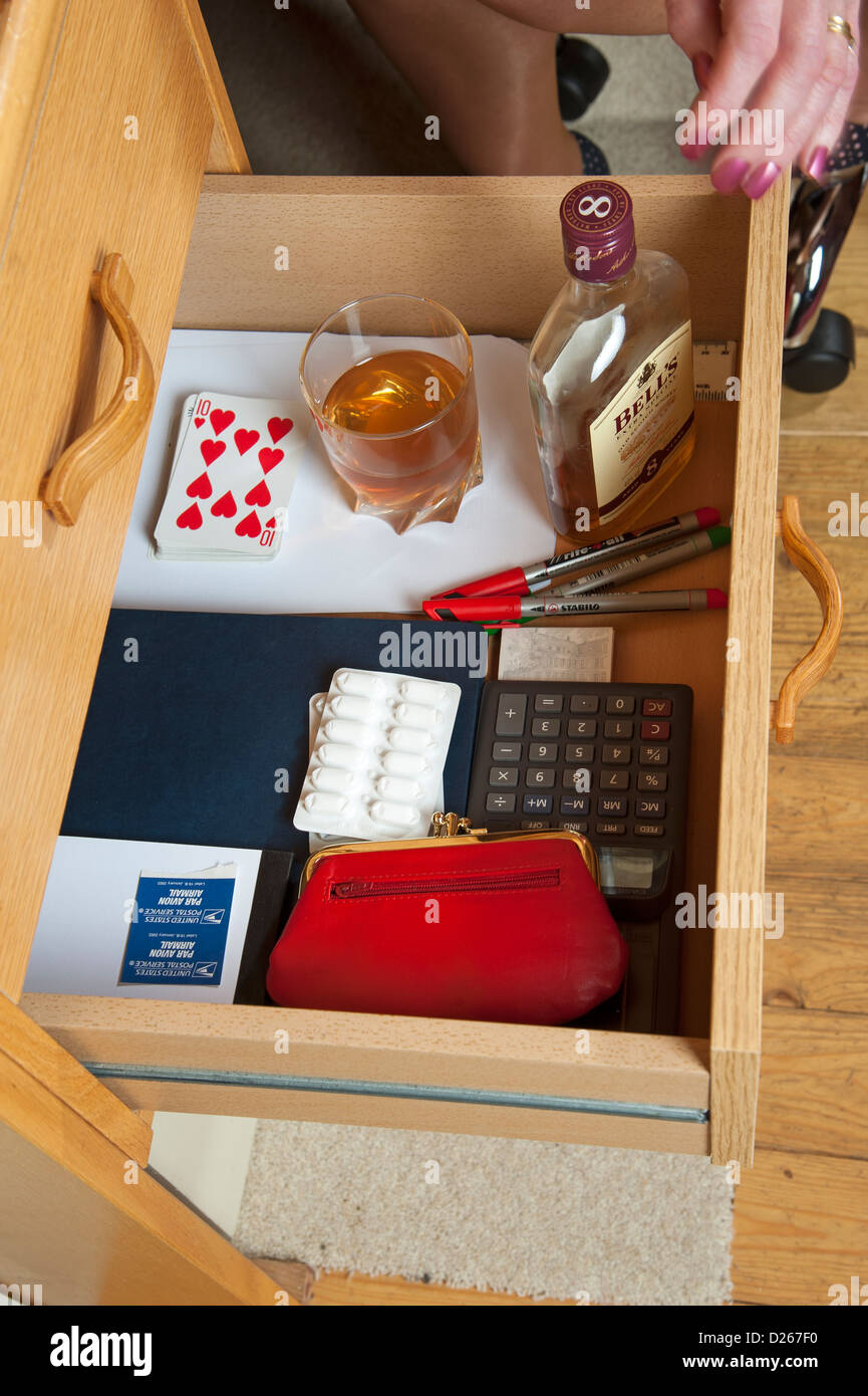 Office drinking problem Woman taking bottle of whiskey from office desk drawer Drinking during