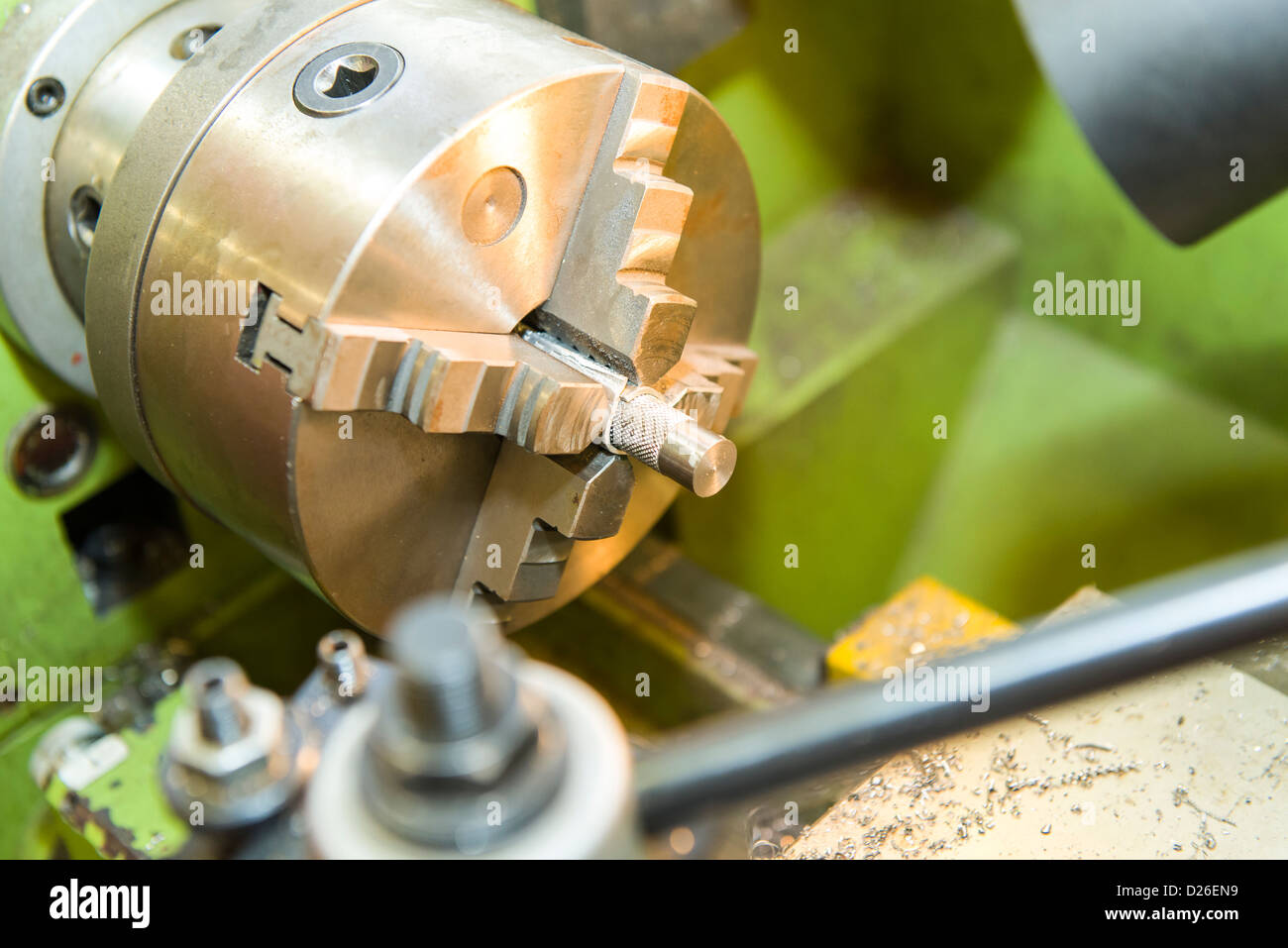 A metal part held in an industrial metal turning lathe using a four jaw chuck Stock Photo