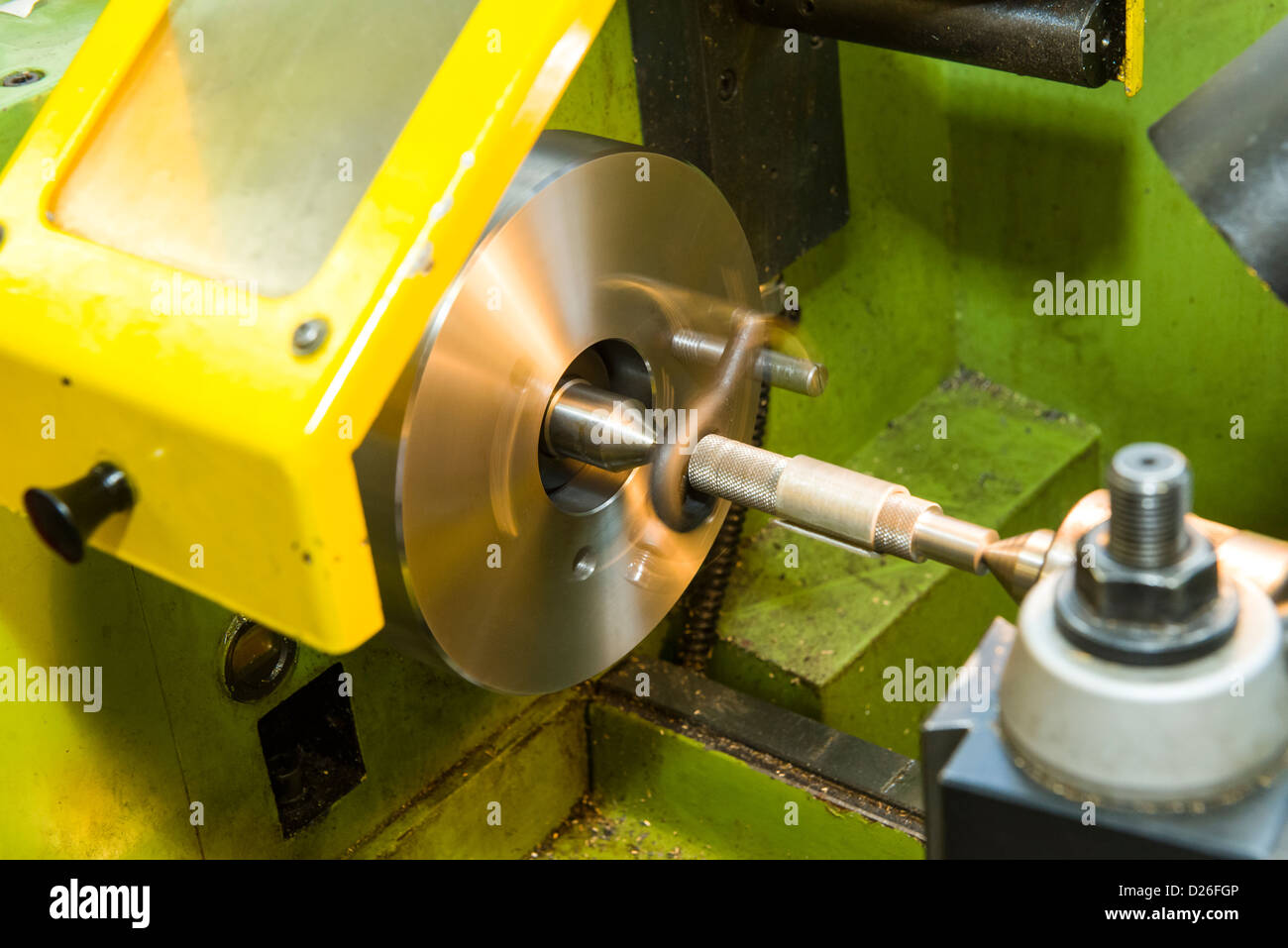 A go-no-go gauge being turned on an industrial metal turning lathe between centres using a face plate and drive dog. Stock Photo