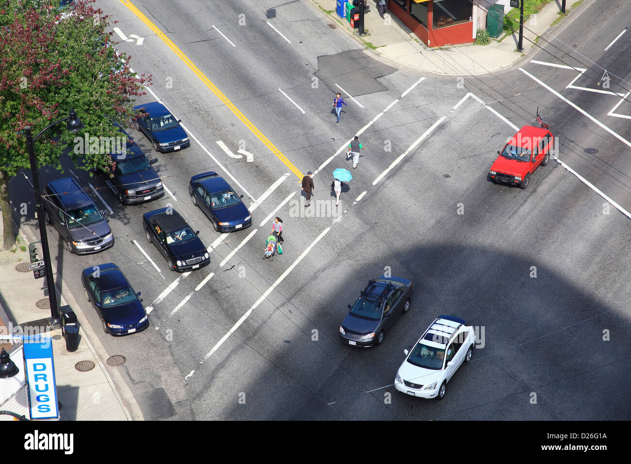 Pedestrians cross busy city street Stock Photo