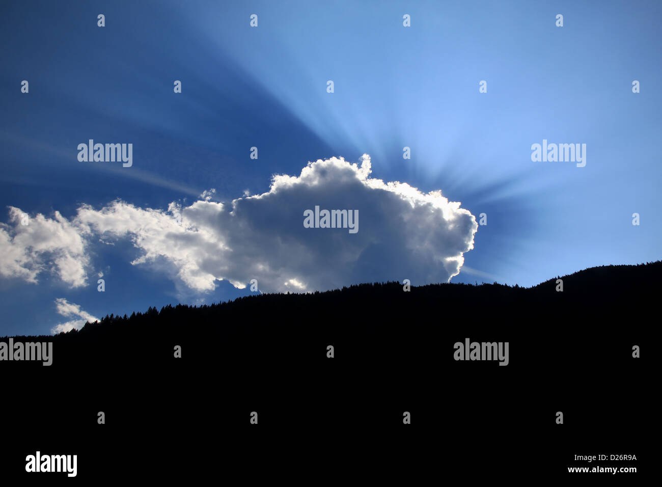 Sunbeams radiate from behind cloud Stock Photo