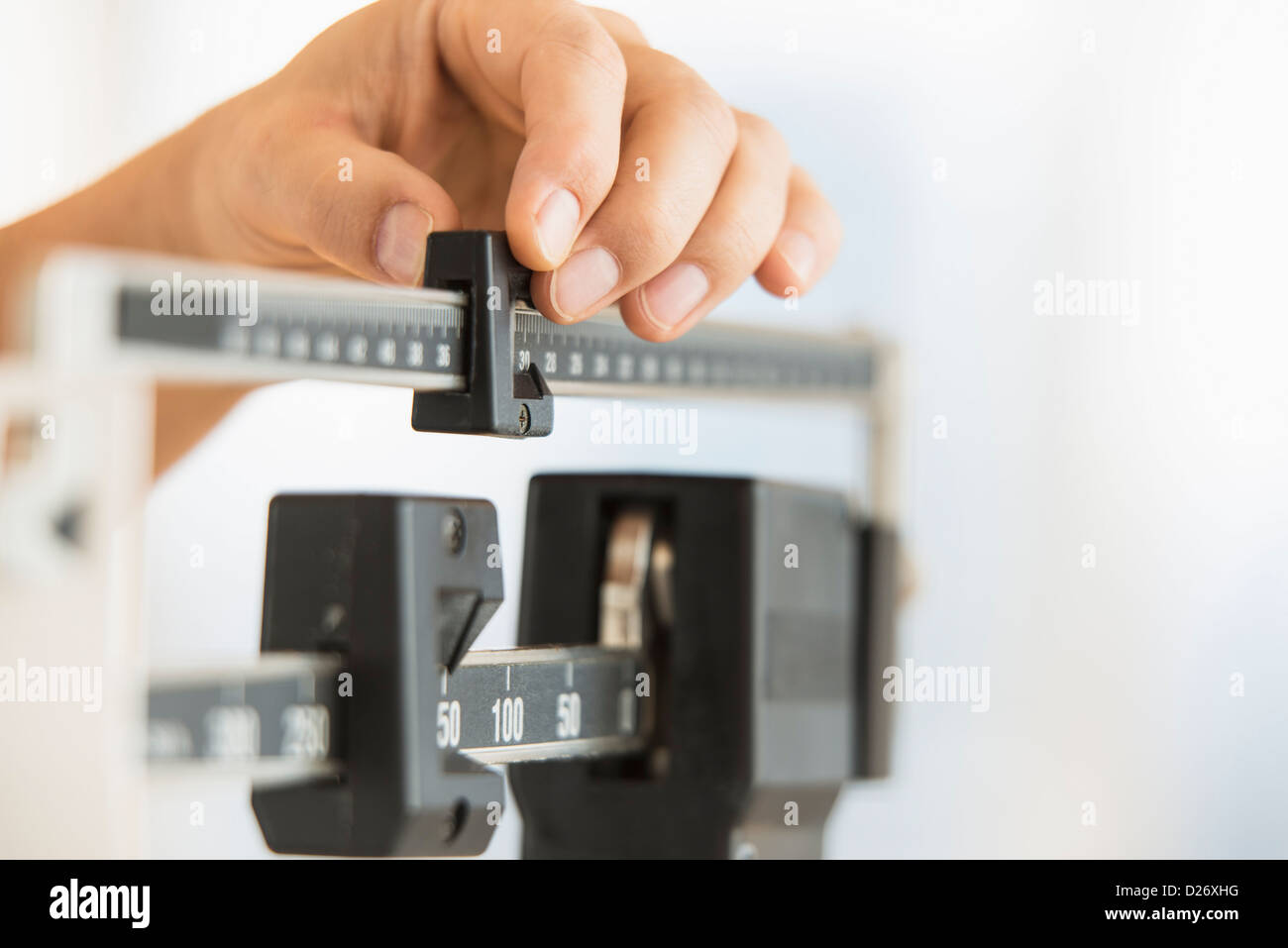 Hand adjusting weight scales Stock Photo