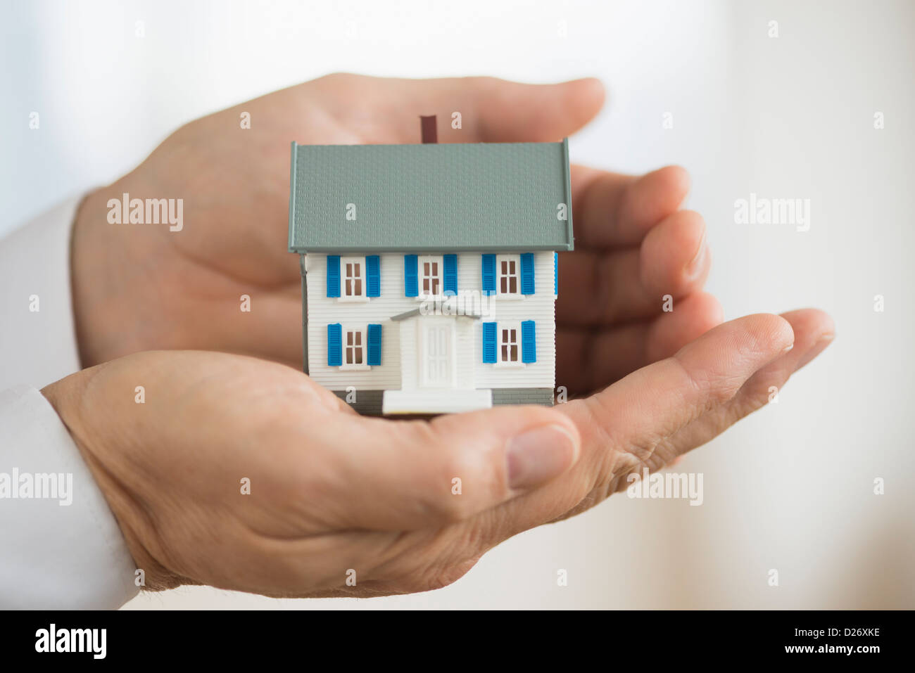 Hands holding model house Stock Photo - Alamy