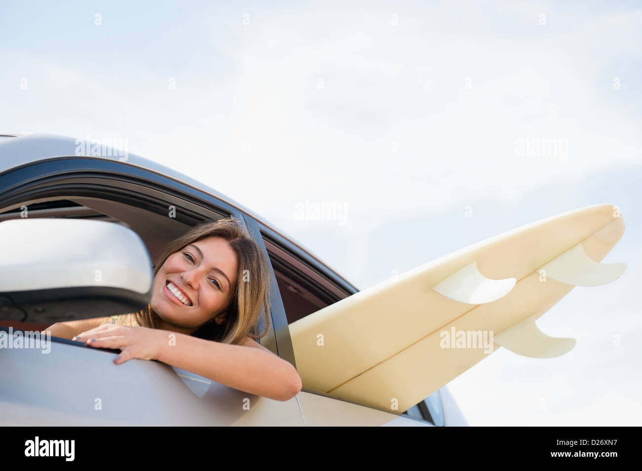 USA, New York State, Rockaway Beach, Woman driving car with surfboard