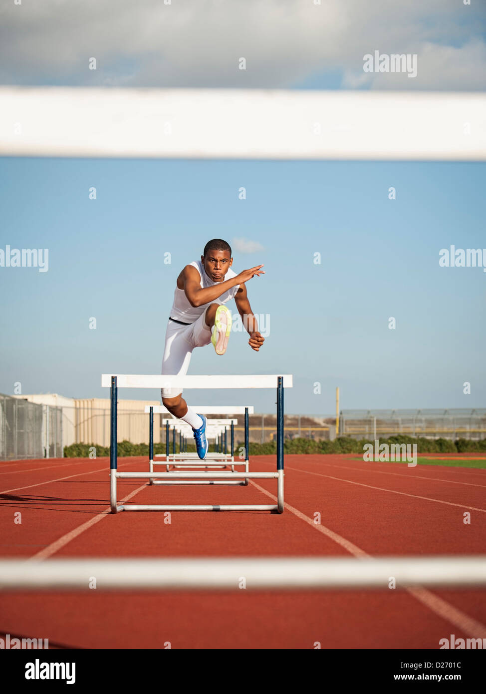 USA, California, Fontana, Boy (12-13) hurdling on running track Stock Photo