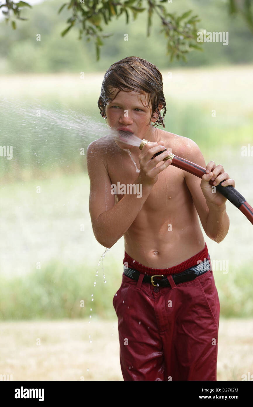 USA, New Jersey, Old Wick, Boy (10-11) drinking from water hose in summer Stock Photo