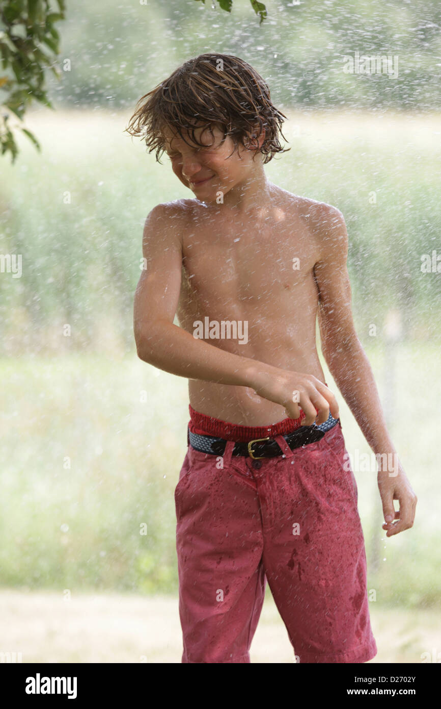 USA, New Jersey, Old Wick, Boy (10-11) playing with splashing water Stock Photo