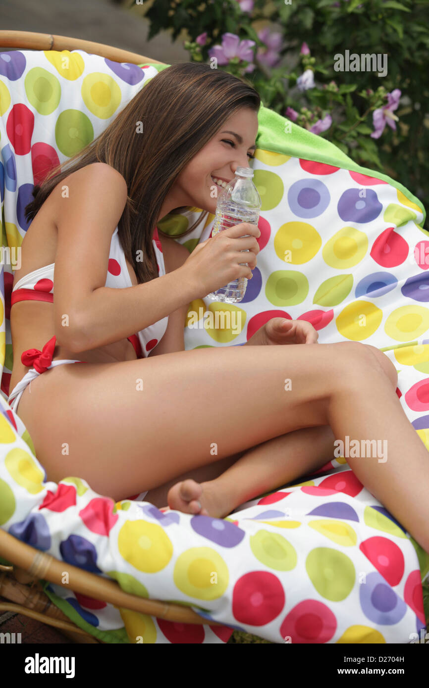 USA, New Jersey, Old Wick, Girl (12-13) in bikini laughing in outdoor chair Stock Photo