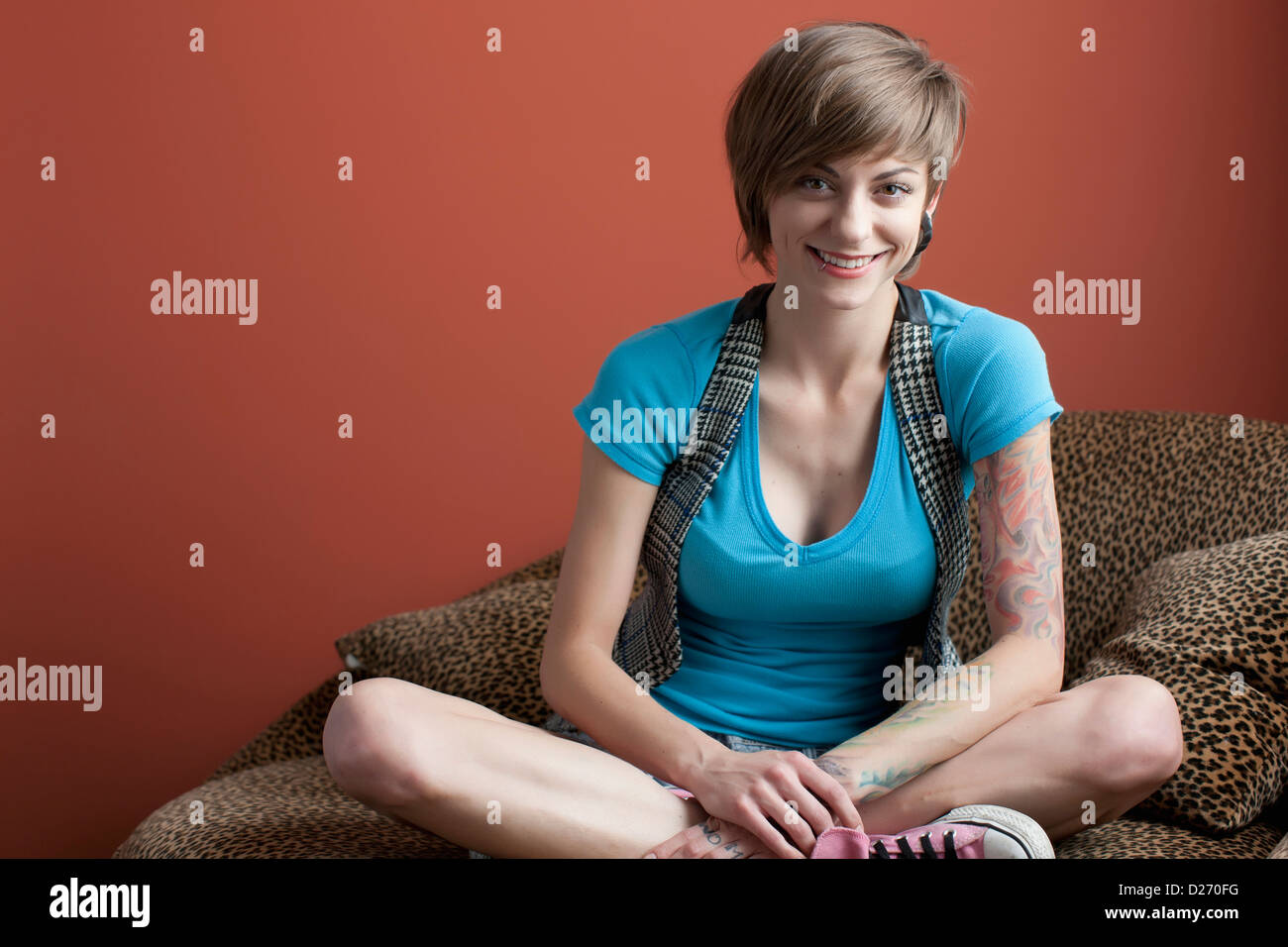 Portrait of young woman sitting on sofa Stock Photo - Alamy