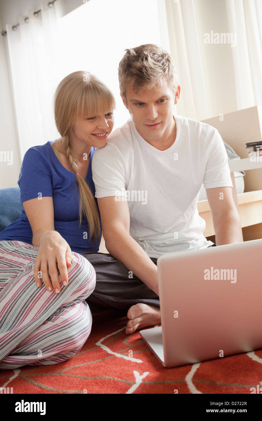 Couple sitting on floor using laptop Stock Photo - Alamy
