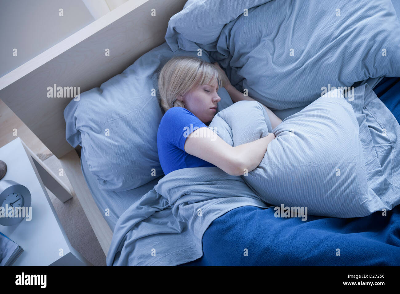 Elevated view of woman sleeping and hugging pillow Stock Photo Alamy