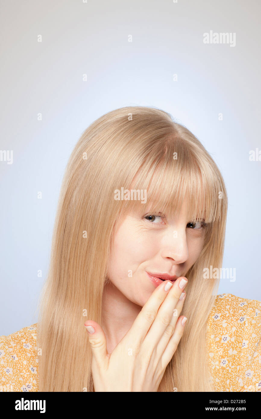 Portrait of woman covering her mouth with hand Stock Photo - Alamy