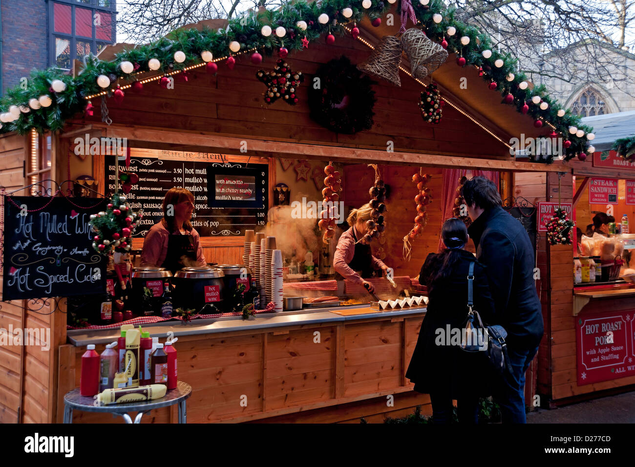 People tourists visitors buying food at Christmas market food stall in
