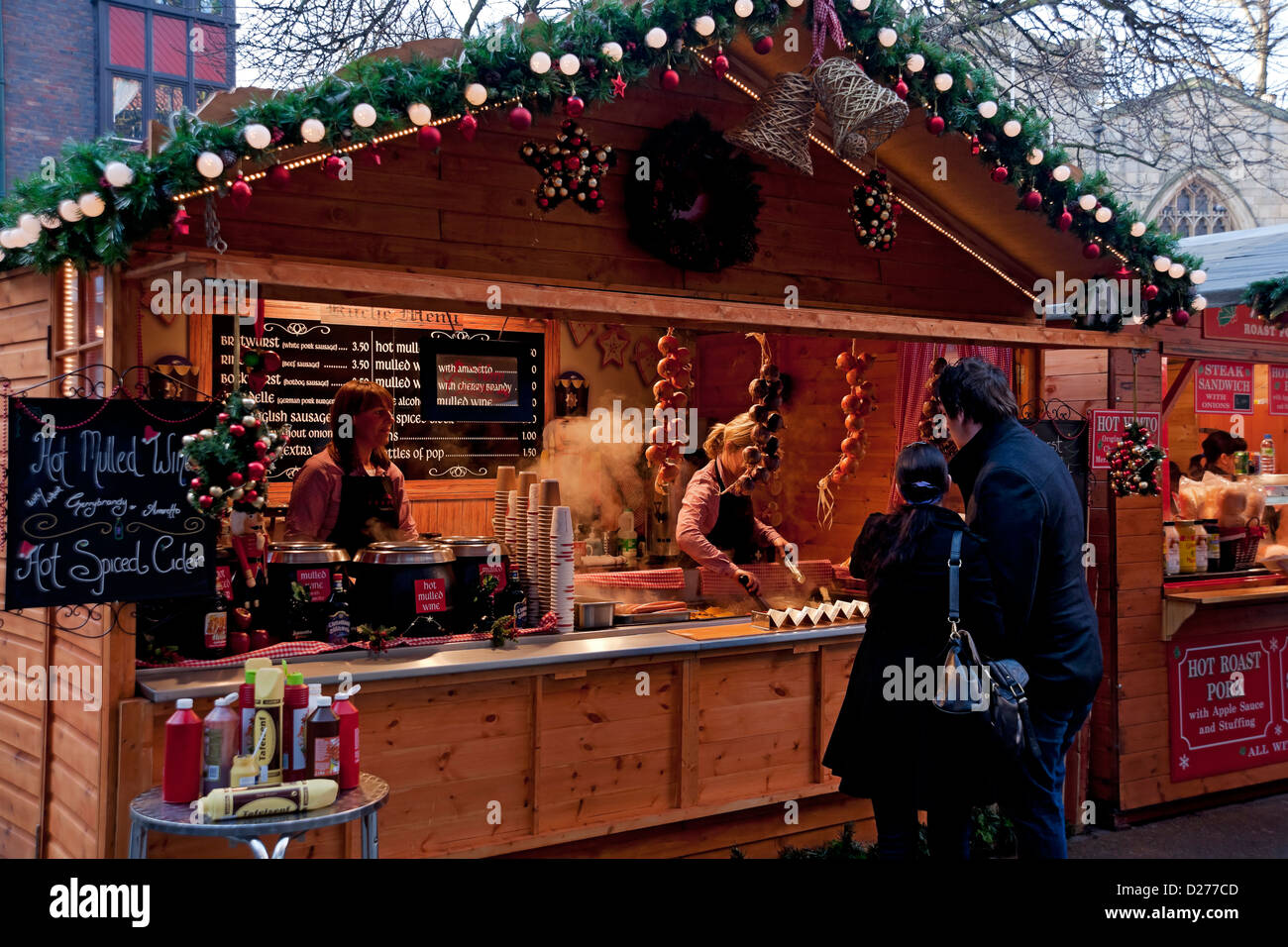 People tourists visitors buying food at Christmas market food stall in winter York North Yorkshire England UK United Kingdom GB Great Britain Stock Photo