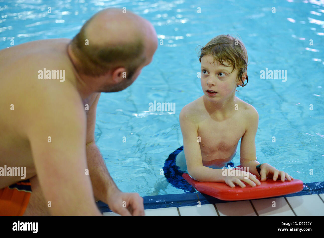 A swimming instructor is giving instructions for the swimming lesson