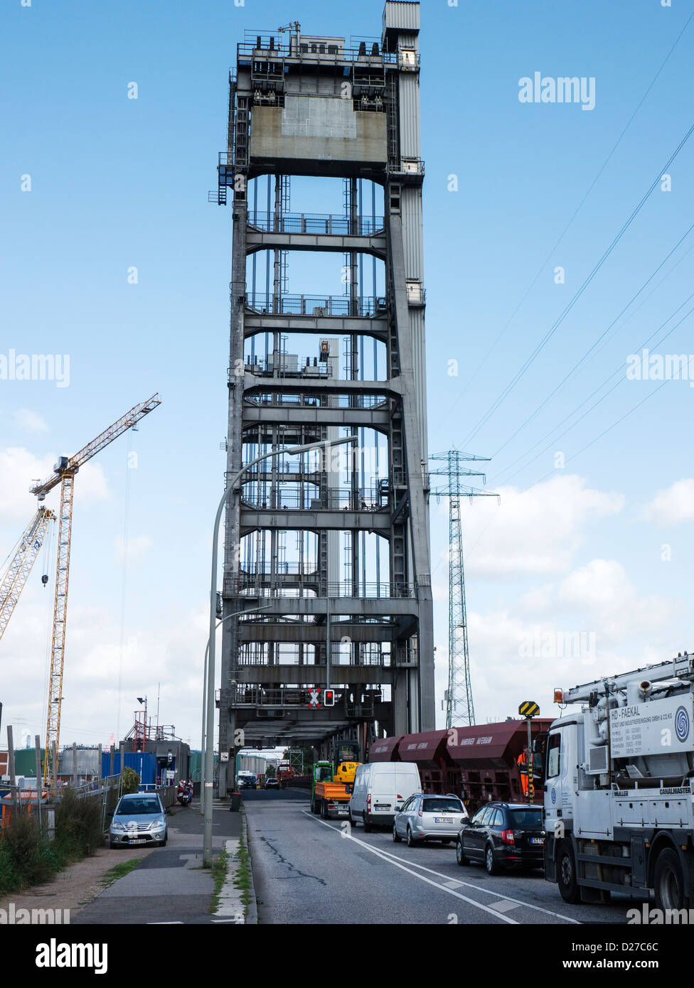 Freight train crossing the lift bridge on Rethedamm while road traffic has to wait in the Port of Hamburg, Germany. Stock Photo