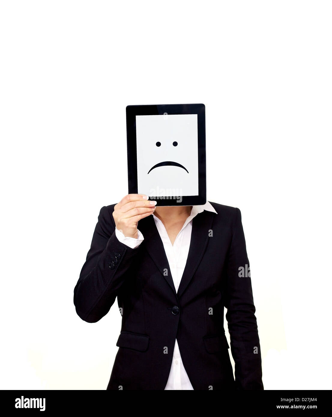 Frustrated professional holding up a digital tablet with a sad emoticon on screen Stock Photo