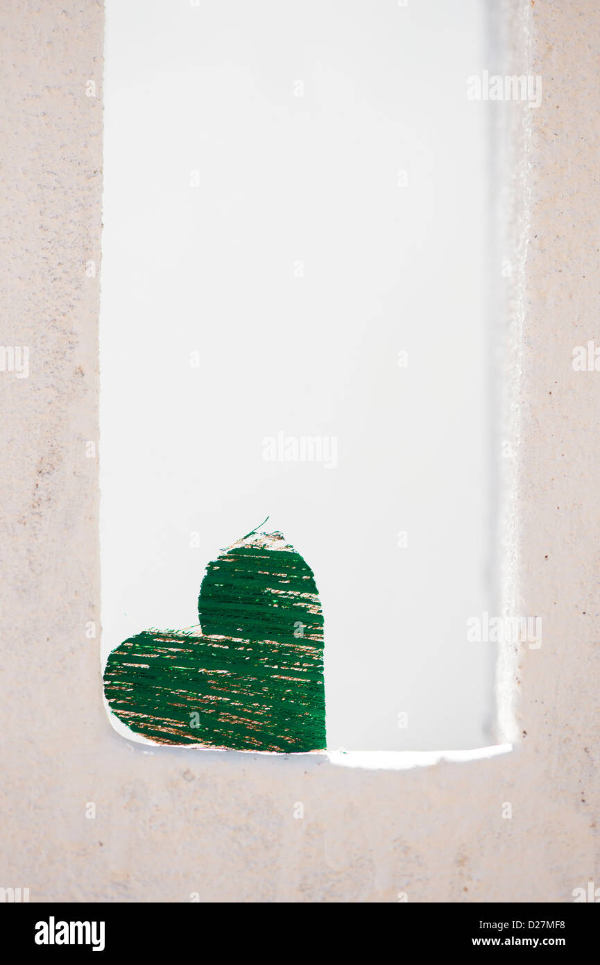 Green coconut husk bark heart shape on a white house balustrade. India Stock Photo