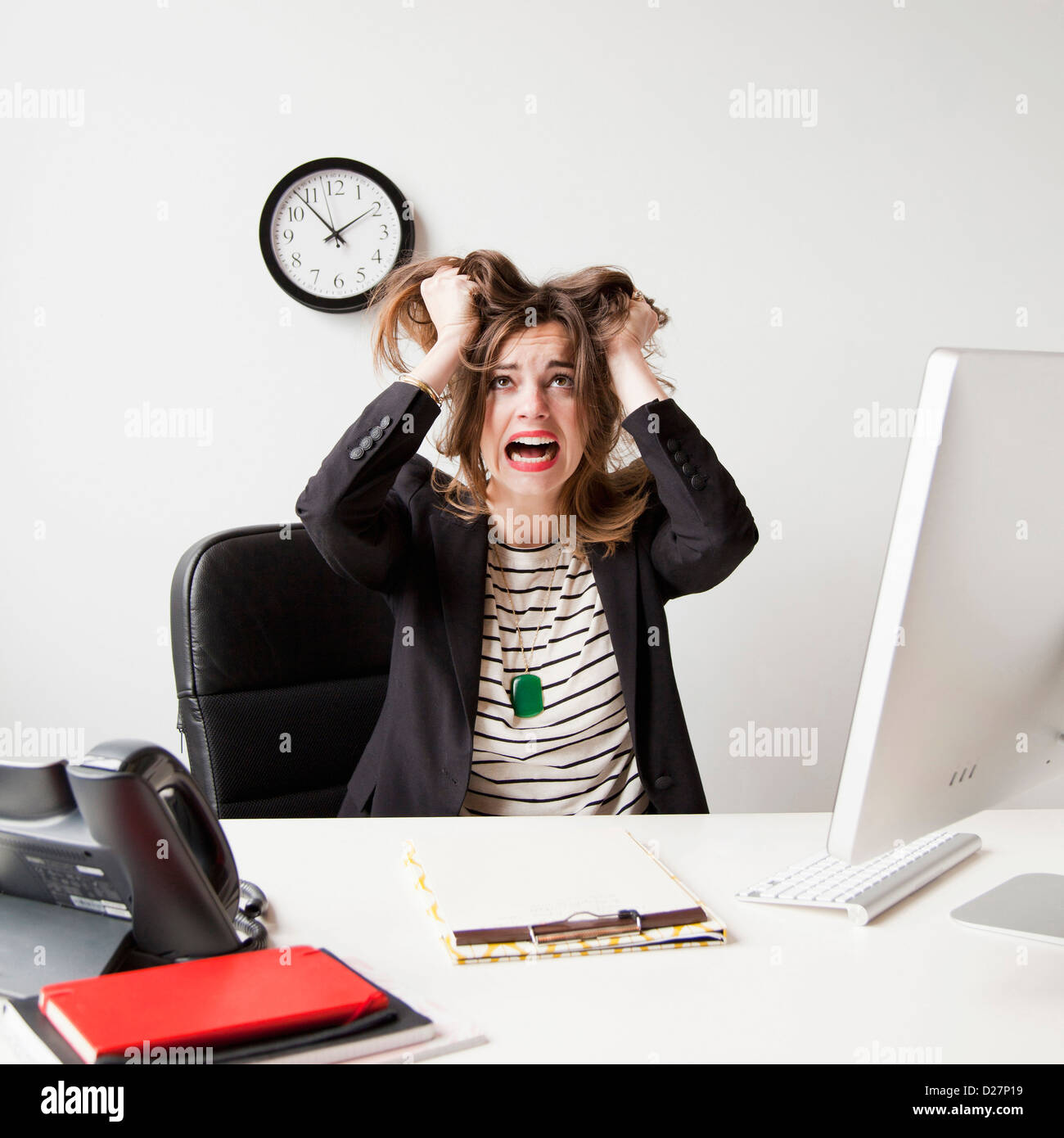 Studio shot of young woman working in office and tearing her hair out Stock Photo