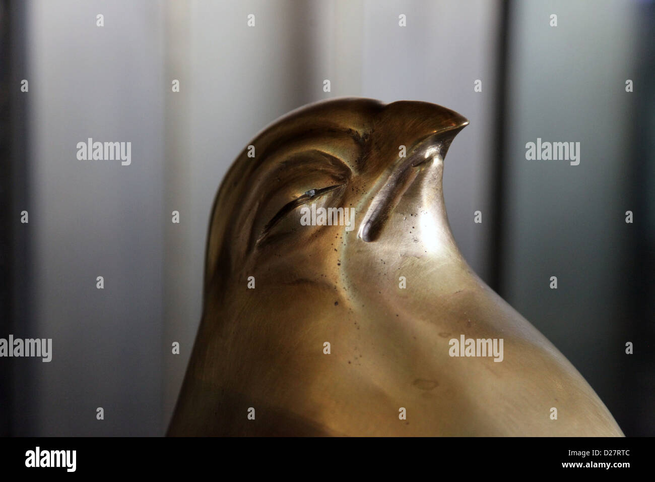 It's a photo of a close up of a head of a statue of a bird in cooper texture. It's a sculpture of a sleeping bird. Focus on him Stock Photo