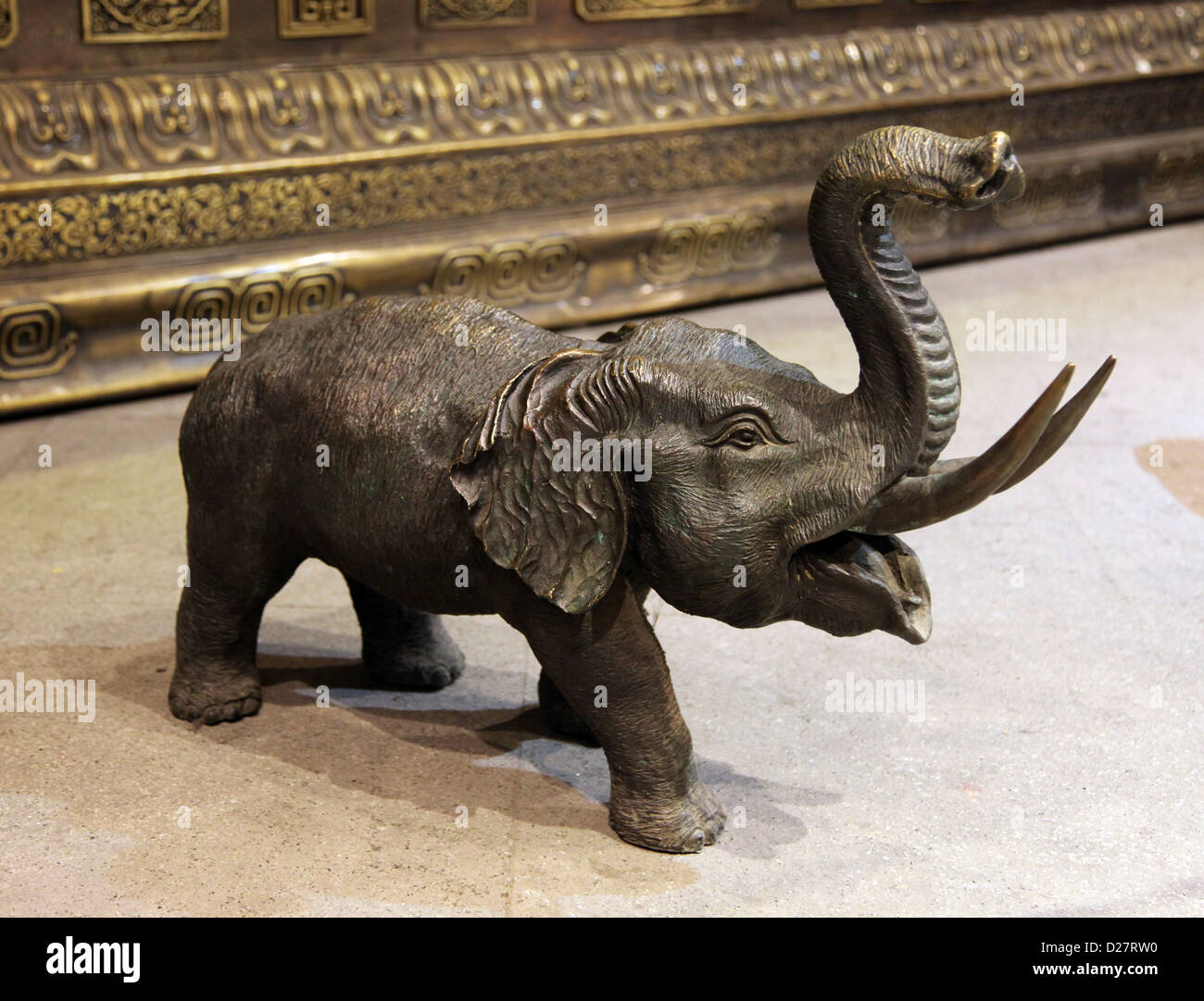 It's a photo of a small statue of an elephant in copper, he is trumpeting. It's in a shop or museum. Stock Photo