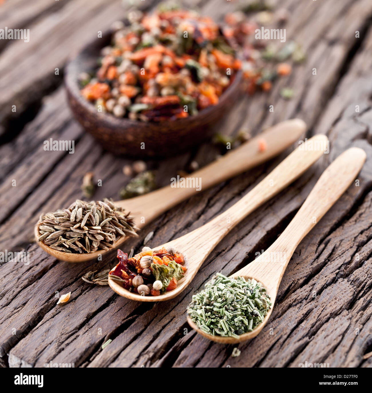 Variety of spices in the spoons on an old wooden table. Stock Photo