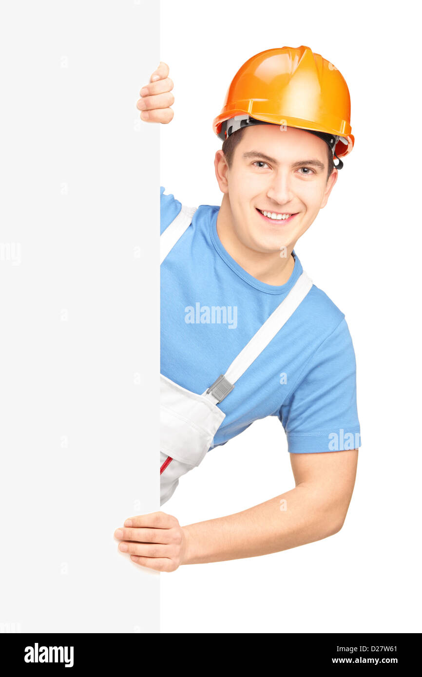 A male worker with helmet posing behind a blank panel isolated on white background Stock Photo
