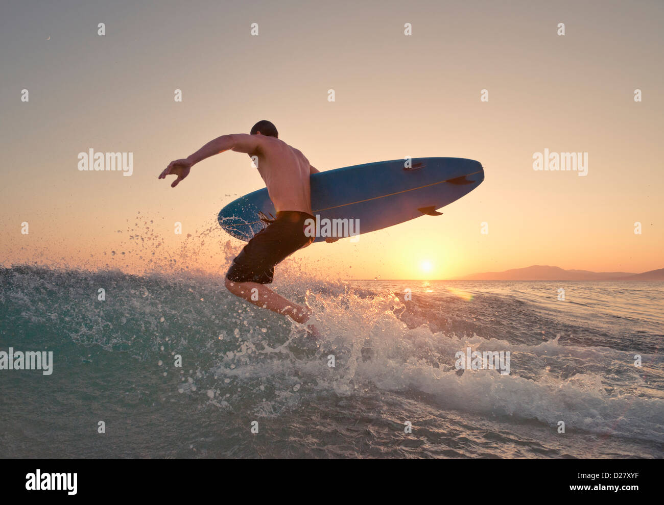 Surfer running into the sea. Stock Photo