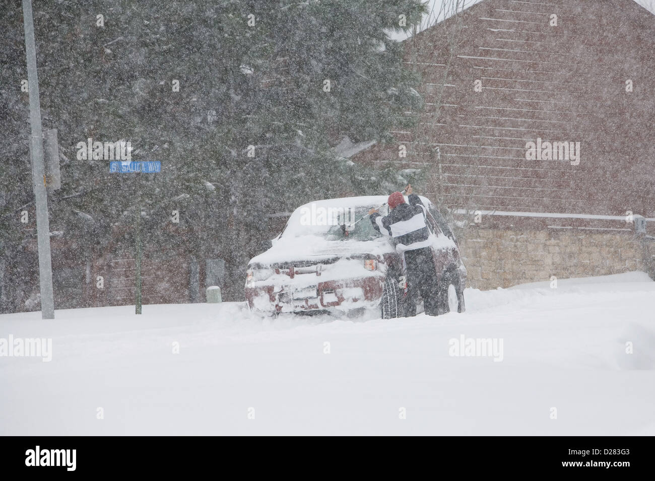 Man cleans windshield during winter blizzard Stock Photo