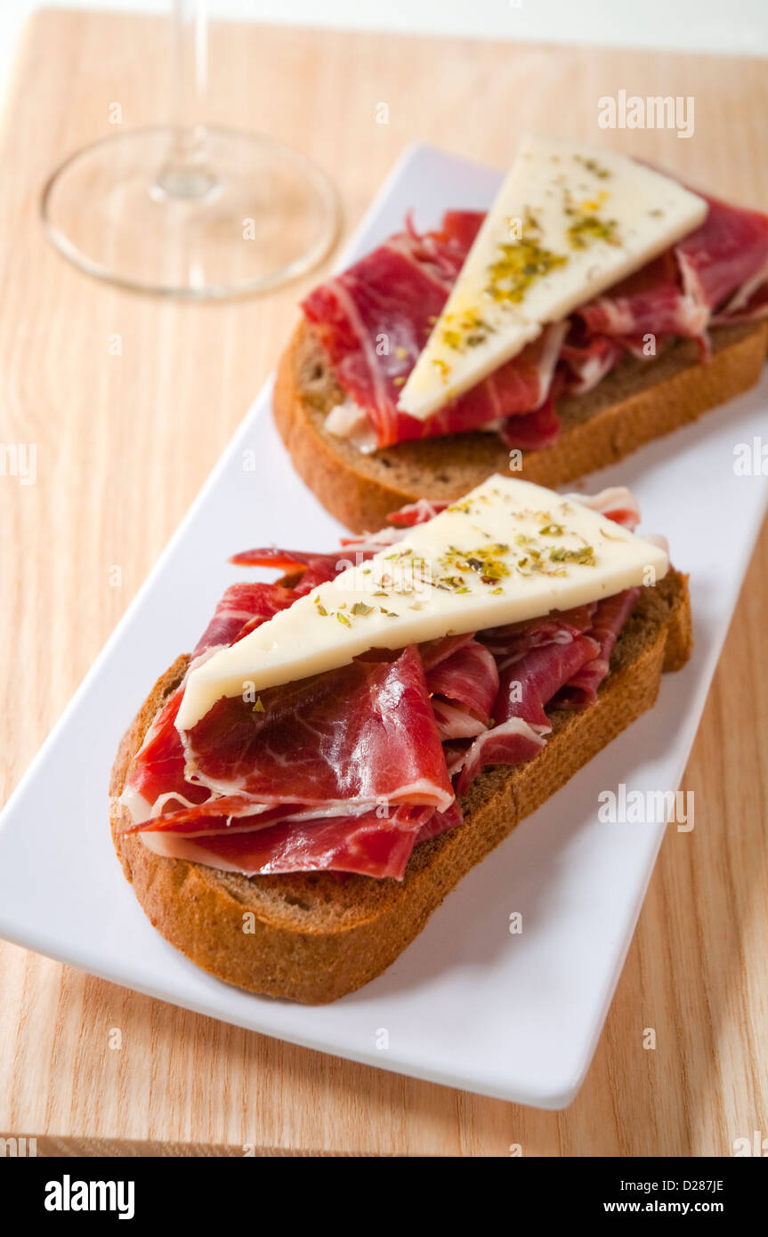 Spanish tapa Iberian ham and cheese on toast. Close view Stock Photo