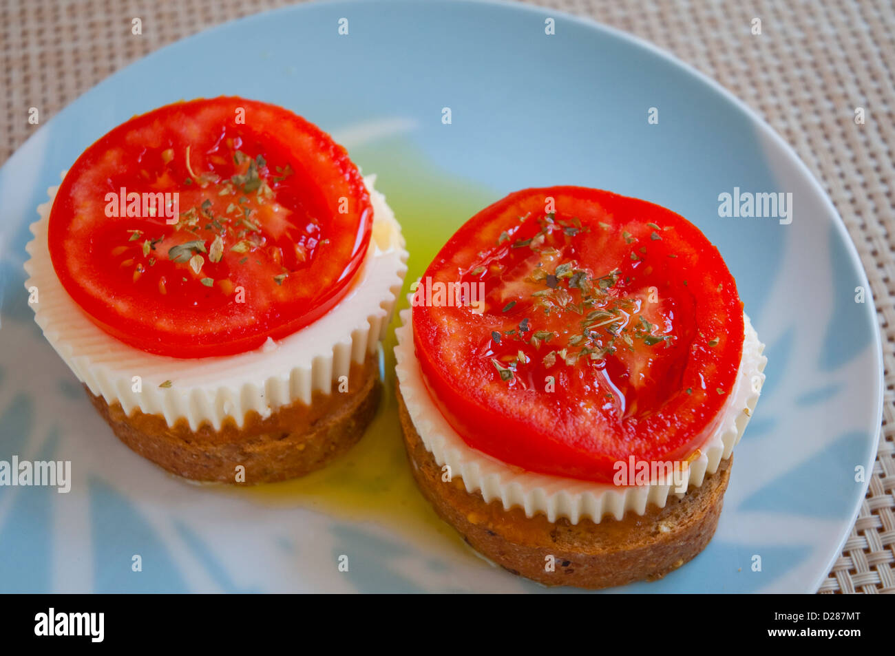 Spanish tapa: Sliced tomato and cottage cheese on toast. Close view. Stock Photo