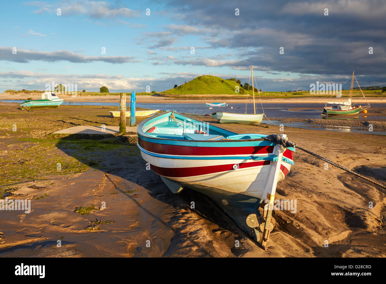 Boats near the mouth of the River Aln in Northumberland with Church Hill  in the background, captured shortly before sunset Stock Photo