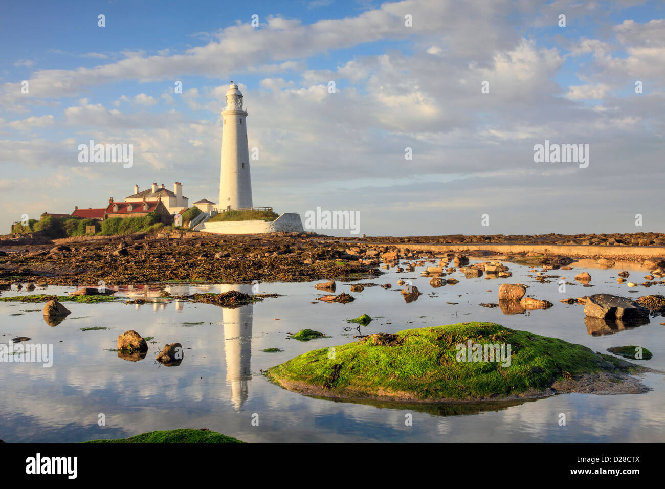 St Mary's Lighthouse near Whitley Bay on the North Tyneside coast,  reflected in a large rock pool adjacent to the causeway. Stock Photo