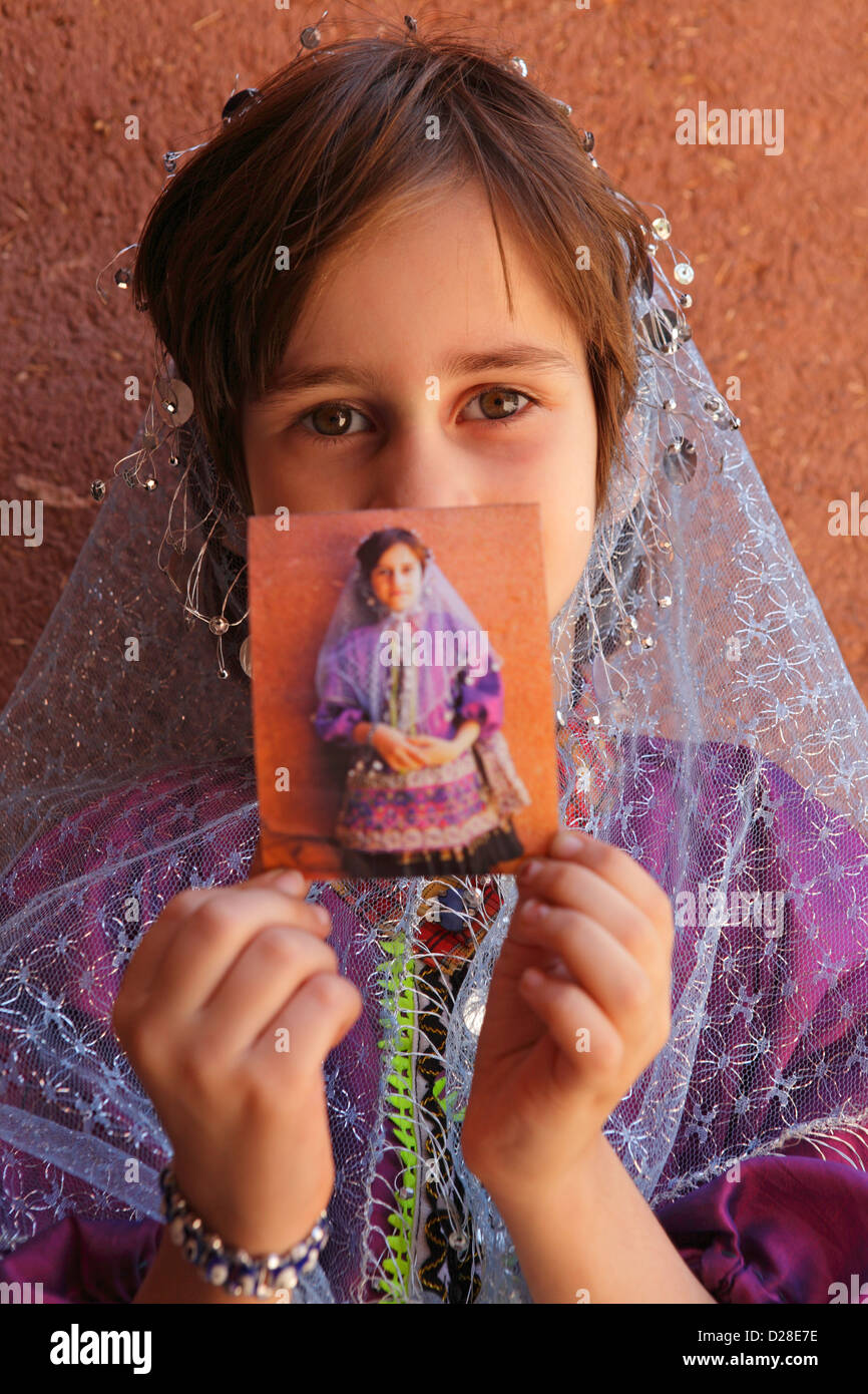 Portrait of a young iranian girl showing a Polaroid, Abyaneh, Iran Stock Photo