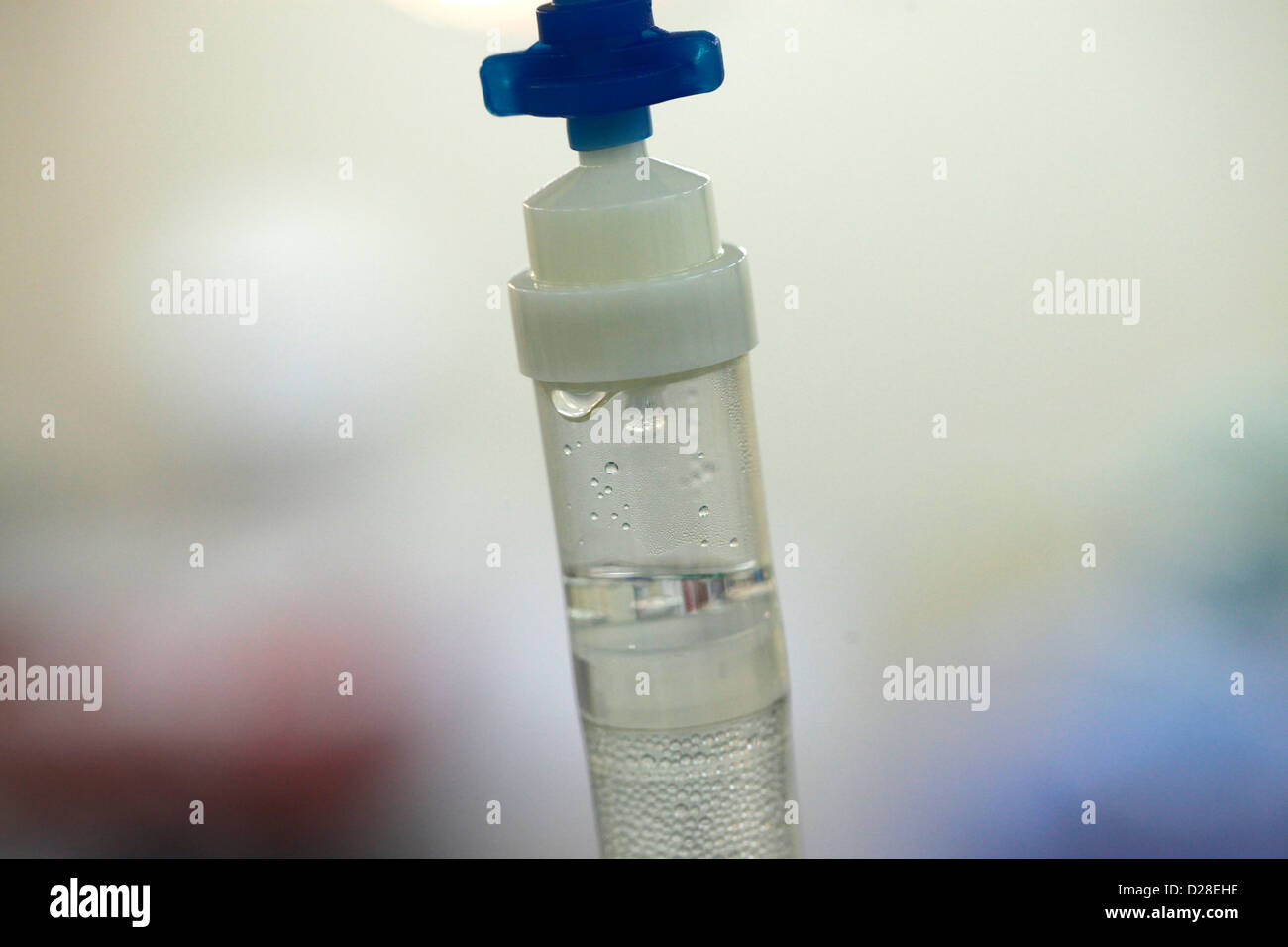 An IV drip chamber connected to saline bag Stock Photo