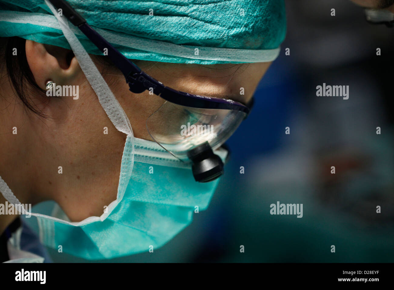 Surgeon wearing surgical mask performing operation in operating room