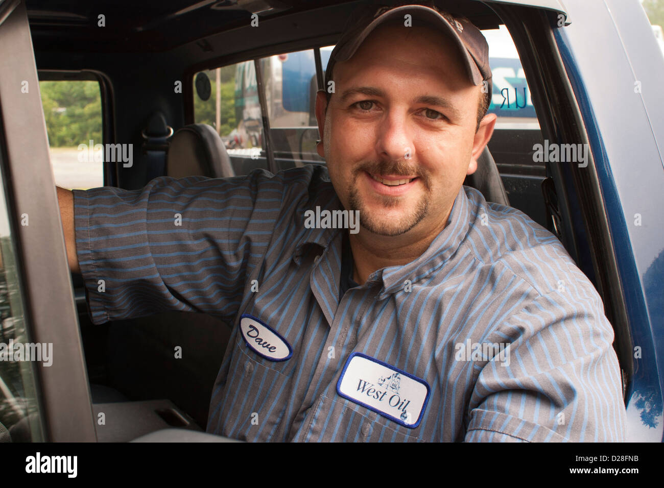 Oil truck driver smiles from his truck Stock Photo Alamy