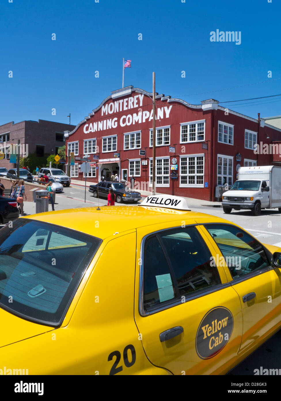 CANNERY ROW AMERICANA YELLOW CAB Monterey Canning Company building flying flag Cannery Row with yellow taxi cab in foreground Monterey California USA Stock Photo