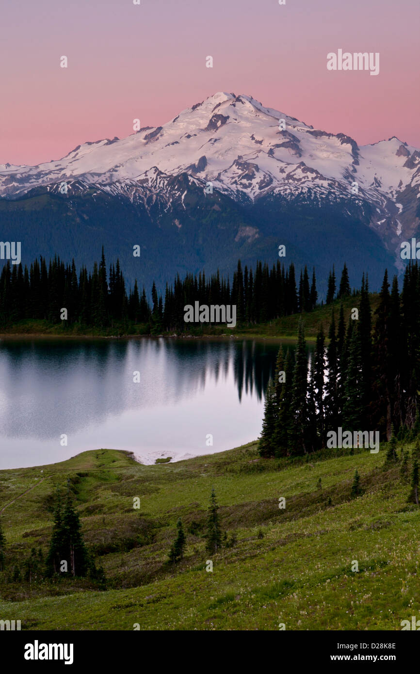 Glacier Peak and pink skies above Image Lake at dawn, Glacier Peak Wilderness, North Cascades, Washington. Stock Photo