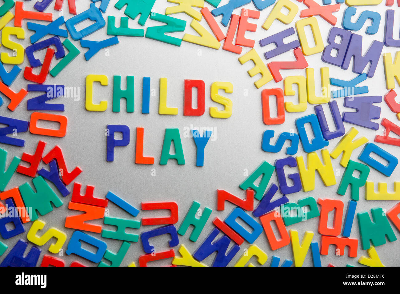 'Childs Play' - Refrigerator magnets spell a message out of a jumble of letters Stock Photo