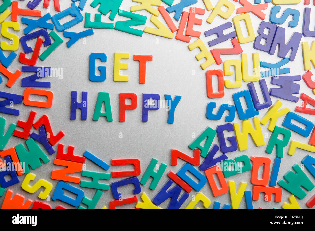 'Get Happy' - Refrigerator magnets spell a message out of a jumble of letters Stock Photo