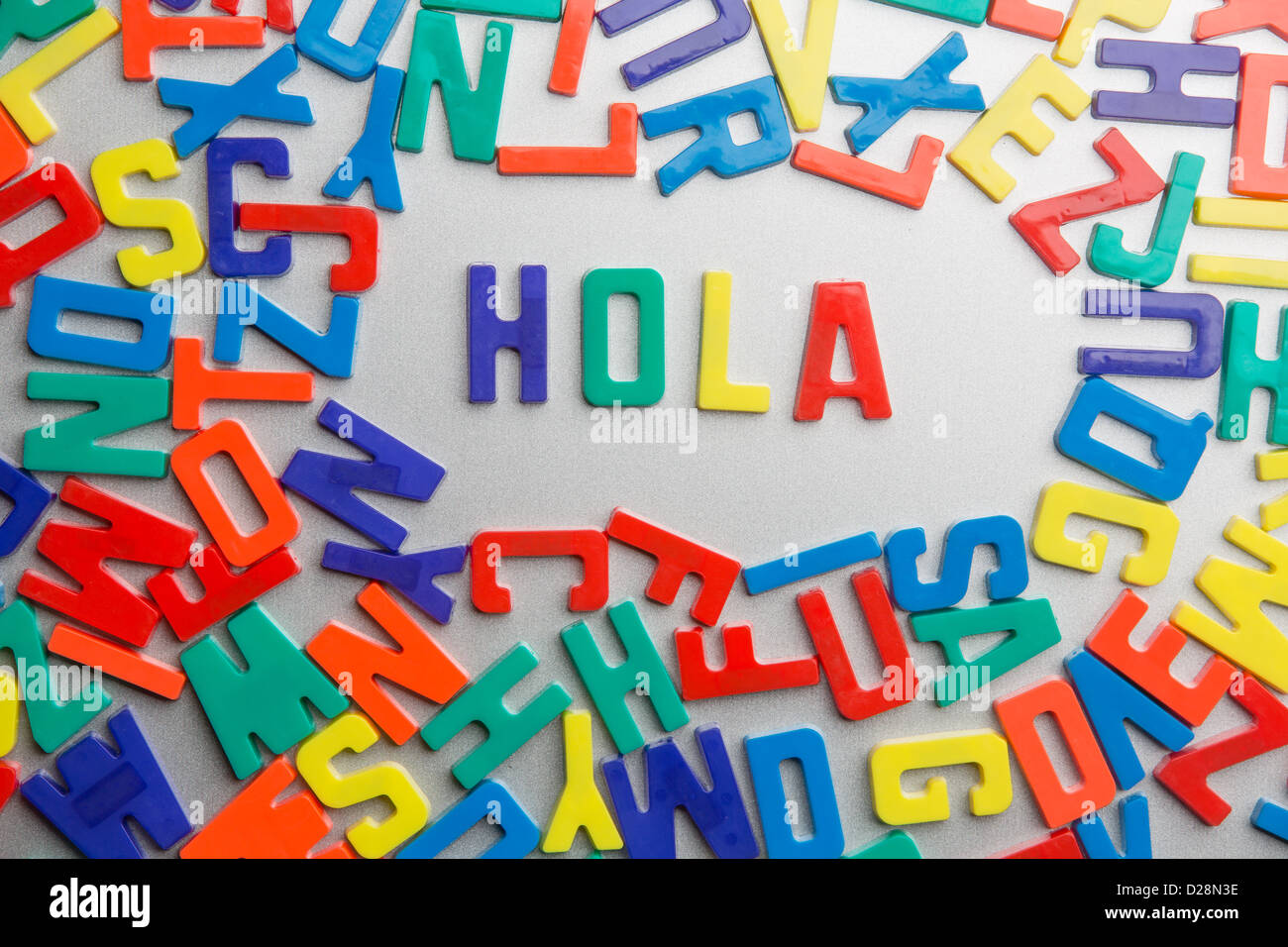 'Hola' - Refrigerator magnets spell a message out of a jumble of letters Stock Photo