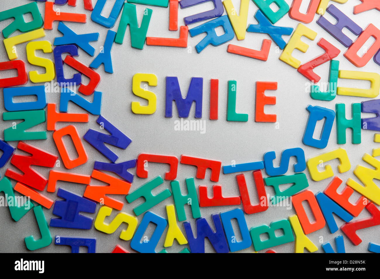 'Smile' - Refrigerator magnets spell a message out of a jumble of letters Stock Photo