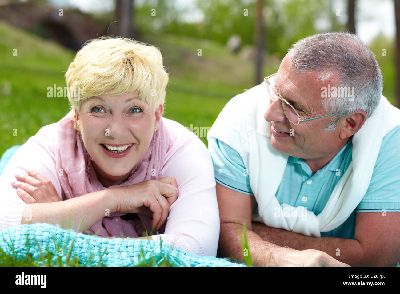 Happy mature couple lying on grass and having rest in summer Stock ...