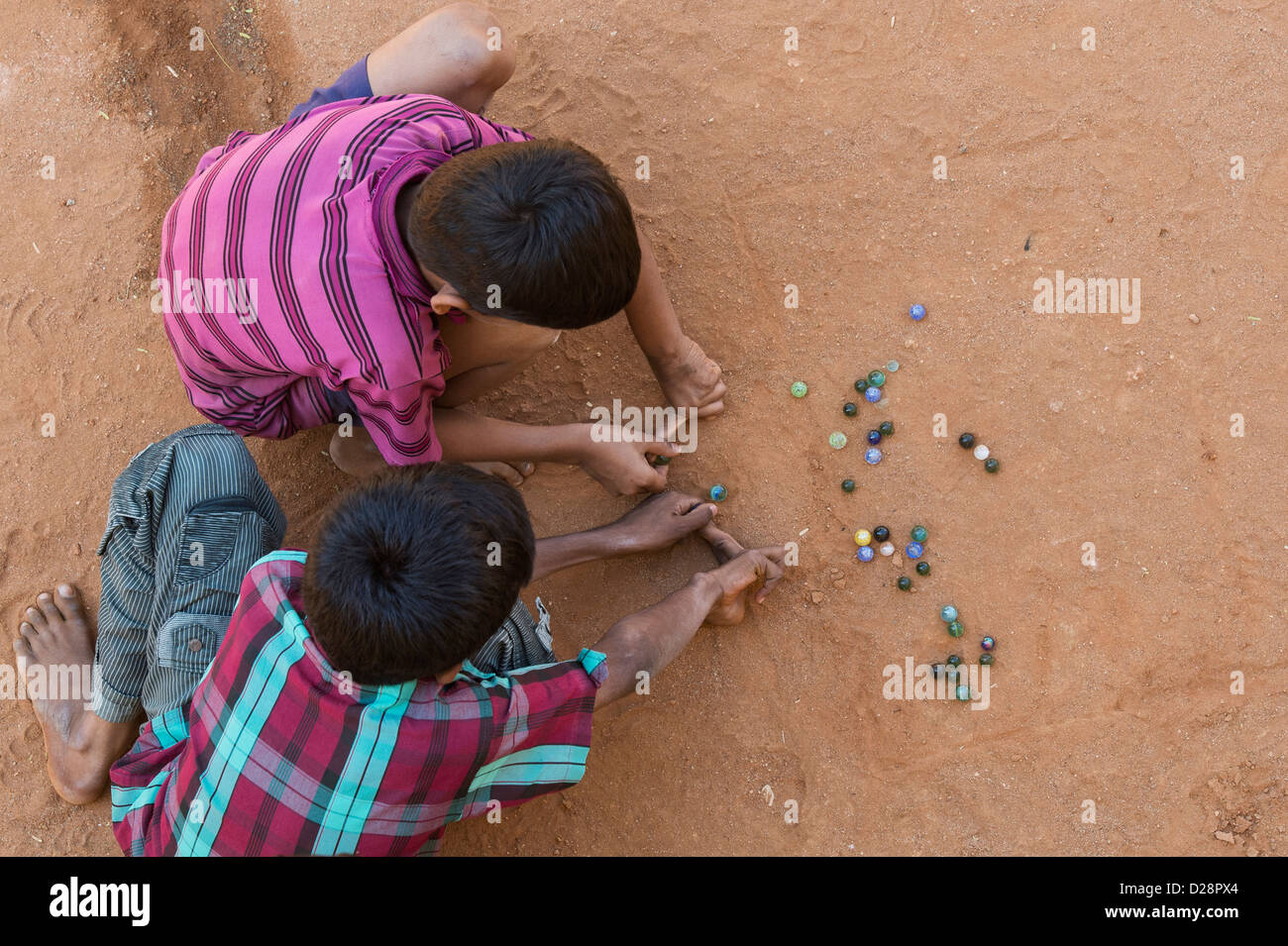 Children playing marbles in street hires stock photography and images