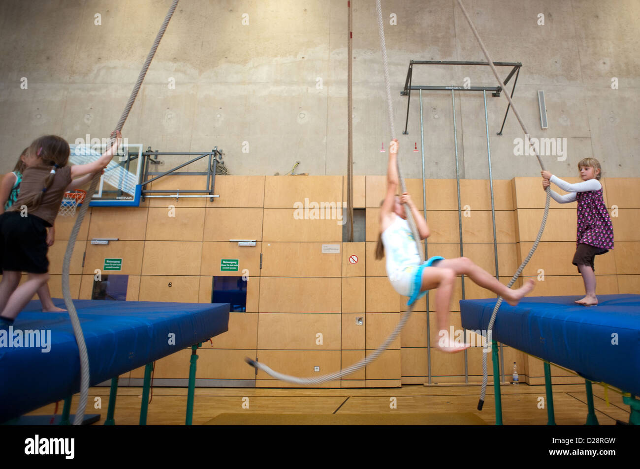 Berlin, Germany, children swing on ropes in a gym Stock Photo